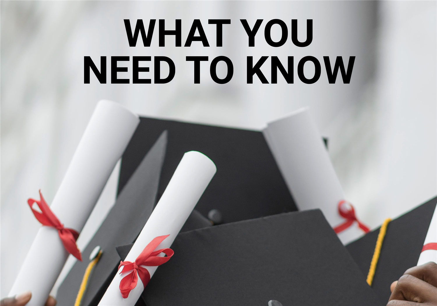 Close up of graduates holding graduation caps